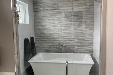 Bathroom - contemporary master gray tile and marble tile gray floor bathroom idea in Denver with shaker cabinets, black cabinets, beige walls, an undermount sink, marble countertops, a hinged shower door and white countertops