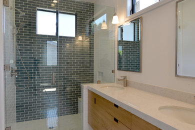 Design ideas for a contemporary master bathroom in Los Angeles with flat-panel cabinets, light wood cabinets, an alcove shower, black tile, blue tile, gray tile, green tile, subway tile, white walls, porcelain floors, an undermount sink, marble benchtops, white floor and a hinged shower door.