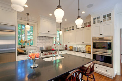 Eat-in kitchen - huge traditional u-shaped medium tone wood floor eat-in kitchen idea in St Louis with an undermount sink, recessed-panel cabinets, white cabinets, granite countertops, white backsplash, stainless steel appliances, an island and subway tile backsplash