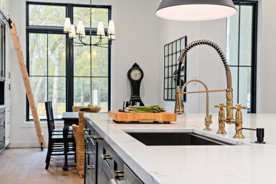Inspiration for a large transitional single-wall light wood floor and beige floor eat-in kitchen remodel in Houston with an undermount sink, shaker cabinets, white cabinets, quartz countertops, white backsplash, porcelain backsplash, stainless steel appliances, an island and white countertops