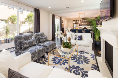 Example of a transitional open concept travertine floor living room design in Los Angeles with beige walls, a standard fireplace, a plaster fireplace and a wall-mounted tv