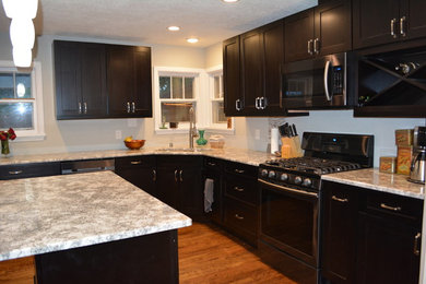 Inspiration for a mid-sized contemporary l-shaped medium tone wood floor eat-in kitchen remodel in Albuquerque with shaker cabinets, dark wood cabinets, quartz countertops, stainless steel appliances and an island