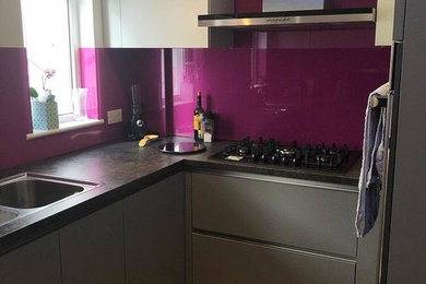 This is an example of a small contemporary u-shaped kitchen in Hertfordshire with flat-panel cabinets, grey cabinets, laminate countertops and pink splashback.
