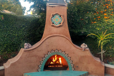 Large southwest backyard concrete paver patio photo in Los Angeles with a fire pit