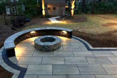 This is an example of a large contemporary backyard patio in Charlotte with a fire feature, concrete pavers and no cover.