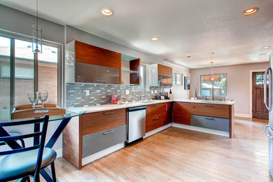 Inspiration for a mid-sized modern l-shaped eat-in kitchen in Denver with an undermount sink, flat-panel cabinets, grey cabinets, quartz benchtops, grey splashback, stainless steel appliances, medium hardwood floors and no island.