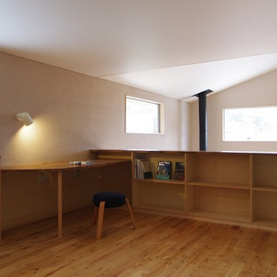 Design ideas for a modern study in Other with white walls, light hardwood flooring, a wood burning stove, a built-in desk and a tiled fireplace surround.