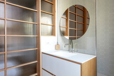 Esempio di una parquet e piastrelle stanza da bagno con doccia minimal di medie dimensioni con ante lisce, ante bianche, doccia aperta, WC a due pezzi, piastrelle bianche, piastrelle in ceramica, pareti bianche, pavimento in legno massello medio, lavabo integrato, top in superficie solida, porta doccia a battente, top bianco, un lavabo e mobile bagno sospeso