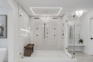 Bathroom - large modern master gray tile and marble tile marble floor, multicolored floor and double-sink bathroom idea in Baltimore with louvered cabinets, brown cabinets, a one-piece toilet, white walls, an undermount sink, quartzite countertops, a hinged shower door, white countertops, a niche and a built-in vanity