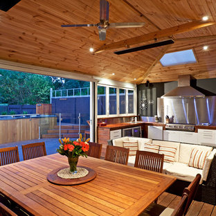 Inspiration pour une véranda chalet avec un sol en bois foncé, aucune cheminée et un puits de lumière.