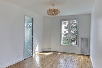 Modelo de salón cerrado y blanco y madera clásico de tamaño medio sin chimenea y televisor con paredes blancas y suelo de madera en tonos medios