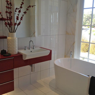 Idee per una stanza da bagno moderna di medie dimensioni con vasca freestanding, piastrelle beige, piastrelle di marmo, pavimento con piastrelle in ceramica, pavimento bianco e top rosso