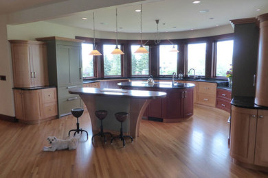 Kitchen - eclectic medium tone wood floor kitchen idea in Calgary with an undermount sink, shaker cabinets, red cabinets, paneled appliances and two islands