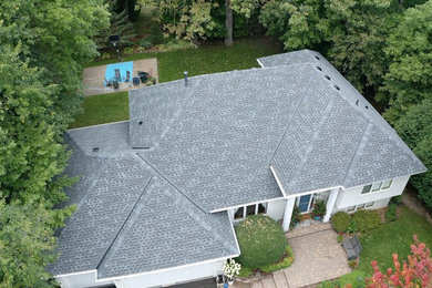 Imagen de fachada gris con tejado de teja de madera