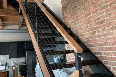 Inspiration for an industrial cable railing staircase remodel in Chicago