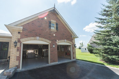 Mid-sized transitional attached two-car garage workshop photo in Toronto