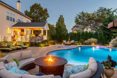 Hot tub - large traditional backyard concrete paver and custom-shaped hot tub idea in Philadelphia