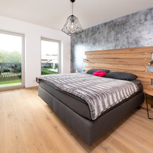 Mittelgroßes Modernes Hauptschlafzimmer ohne Kamin mit weißer Wandfarbe, braunem Holzboden und beigem Boden in Nürnberg