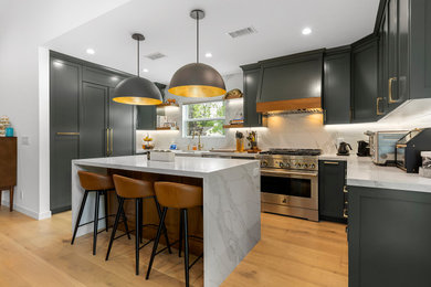 Kitchen - transitional light wood floor and brown floor kitchen idea in Los Angeles with a farmhouse sink, shaker cabinets, gray cabinets, quartz countertops, quartz backsplash, stainless steel appliances, an island and white countertops