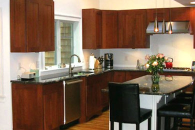 Eat-in kitchen - mid-sized traditional u-shaped eat-in kitchen idea in Philadelphia with flat-panel cabinets, dark wood cabinets and an island