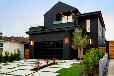 Large trendy black two-story wood and clapboard house exterior photo in Los Angeles with a shed roof, a mixed material roof and a black roof
