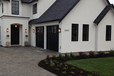 Large traditional white two-story stucco exterior home idea in Vancouver with a shingle roof