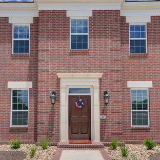 オースティンのトラディショナルスタイルのおしゃれな家の外観 (レンガサイディング、赤い外壁、切妻屋根、戸建、板屋根) の写真
