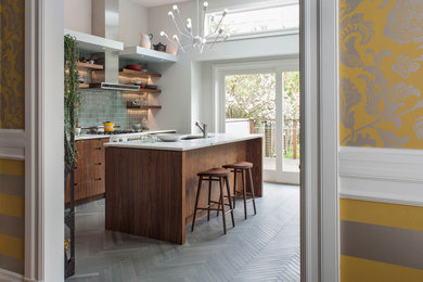 Design ideas for a contemporary galley kitchen in San Francisco with flat-panel cabinets, dark wood cabinets, blue splashback, stainless steel appliances and grey floor.