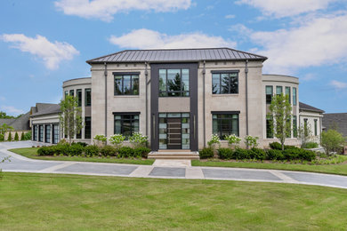 Inspiration for a large modern beige two-story stone house exterior remodel in Chicago with a hip roof, a metal roof and a brown roof