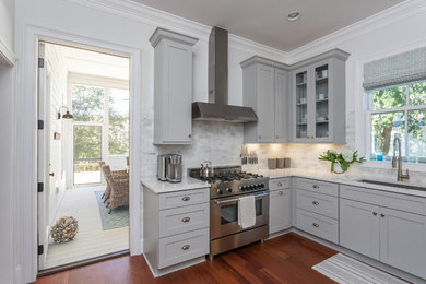 Inspiration for a mid-sized coastal l-shaped medium tone wood floor eat-in kitchen remodel in Charleston with an undermount sink, recessed-panel cabinets, gray cabinets, marble countertops, gray backsplash, ceramic backsplash, stainless steel appliances and no island
