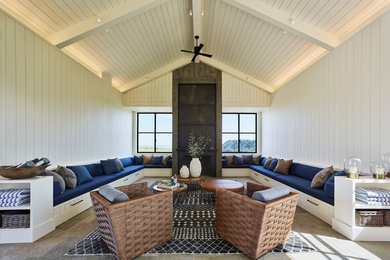 Example of a farmhouse open concept slate floor and multicolored floor game room design in San Francisco with white walls, a standard fireplace, a concrete fireplace and a concealed tv