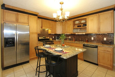 Photo of a mid-sized traditional l-shaped eat-in kitchen in New York with a single-bowl sink, flat-panel cabinets, medium wood cabinets, granite benchtops, metallic splashback, stainless steel appliances, porcelain floors and with island.