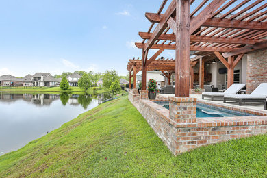 Patio fountain - mid-sized traditional backyard concrete patio fountain idea in Other with a pergola