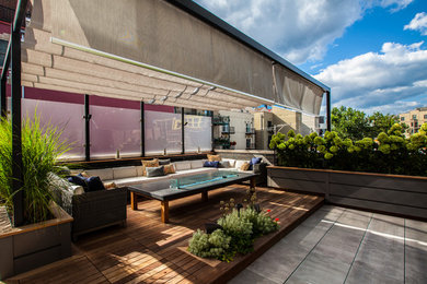 Design ideas for a mid-sized contemporary rooftop deck in Chicago with an outdoor kitchen and an awning.