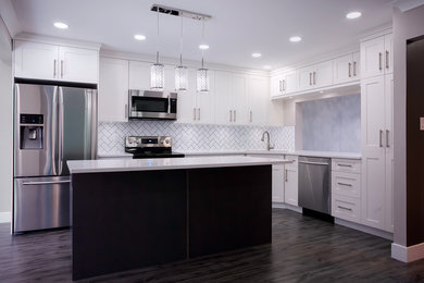 Inspiration for a mid-sized contemporary l-shaped dark wood floor enclosed kitchen remodel in Vancouver with an undermount sink, shaker cabinets, white cabinets, quartz countertops, white backsplash, subway tile backsplash, stainless steel appliances and an island