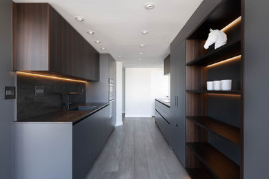 Large contemporary kitchen in Vancouver with flat-panel cabinets, medium wood cabinets, light hardwood floors and grey floor.