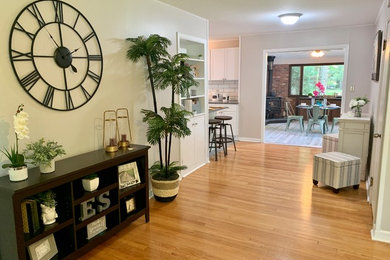 Example of a transitional light wood floor and beige floor hallway design in New York with green walls
