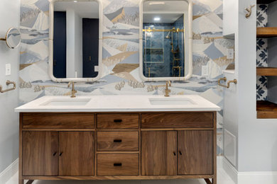 Example of a large transitional master blue tile and mosaic tile marble floor, white floor, double-sink and wallpaper bathroom design in DC Metro with flat-panel cabinets, medium tone wood cabinets, a wall-mount toilet, blue walls, an undermount sink, quartz countertops, white countertops, a niche and a freestanding vanity
