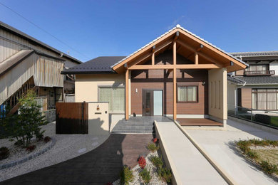 Foto de fachada de casa beige y gris de dos plantas con tejado a dos aguas y tejado de teja de barro