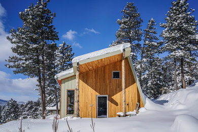 Rustic two-story wood exterior home idea in Denver with a shed roof
