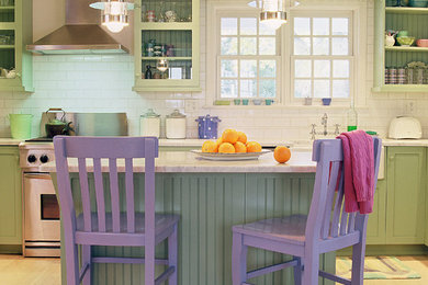 Example of a mid-sized classic l-shaped light wood floor open concept kitchen design in Jacksonville with a farmhouse sink, flat-panel cabinets, green cabinets, white backsplash, stainless steel appliances, an island, marble countertops, ceramic backsplash and white countertops