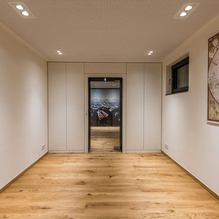 Design ideas for a medium sized romantic fully buried basement in Other with white walls, medium hardwood flooring and brown floors.