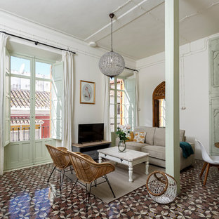 Design ideas for a mediterranean open plan living room in Malaga with white walls, a freestanding tv and brown floors.