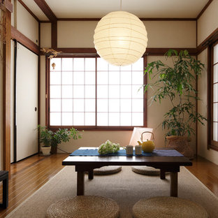 Modelo de salón asiático, de tamaño medio, sin chimenea, con paredes beige, suelo de madera en tonos medios y suelo marrón