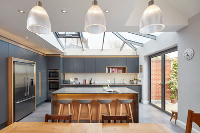 Large contemporary l-shaped kitchen/diner in London with a submerged sink, flat-panel cabinets, grey cabinets, white splashback and an island.