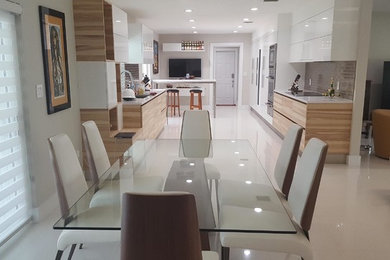 Inspiration for a mid-sized modern galley porcelain tile and white floor eat-in kitchen remodel in Miami with an undermount sink, flat-panel cabinets, quartzite countertops, glass tile backsplash, paneled appliances, light wood cabinets, gray backsplash and no island