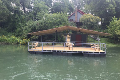 Example of a mid-sized backyard dock design in Little Rock with a roof extension