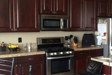 Large elegant single-wall kitchen photo in Other with dark wood cabinets, stainless steel appliances and an island