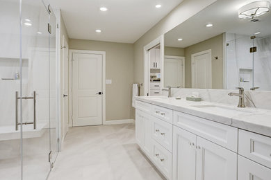 Transitional master bathroom in Houston with flat-panel cabinets, white cabinets, a curbless shower, a one-piece toilet, beige walls, an undermount sink, quartzite benchtops, beige floor, a hinged shower door, a shower seat, a double vanity and a built-in vanity.