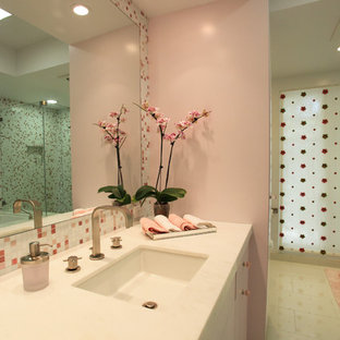 Esempio di una stanza da bagno per bambini moderna di medie dimensioni con ante bianche, lavabo sottopiano, pareti rosa, ante lisce, vasca ad alcova, doccia alcova, WC a due pezzi, piastrelle bianche, piastrelle di vetro, pavimento in gres porcellanato e top in marmo
